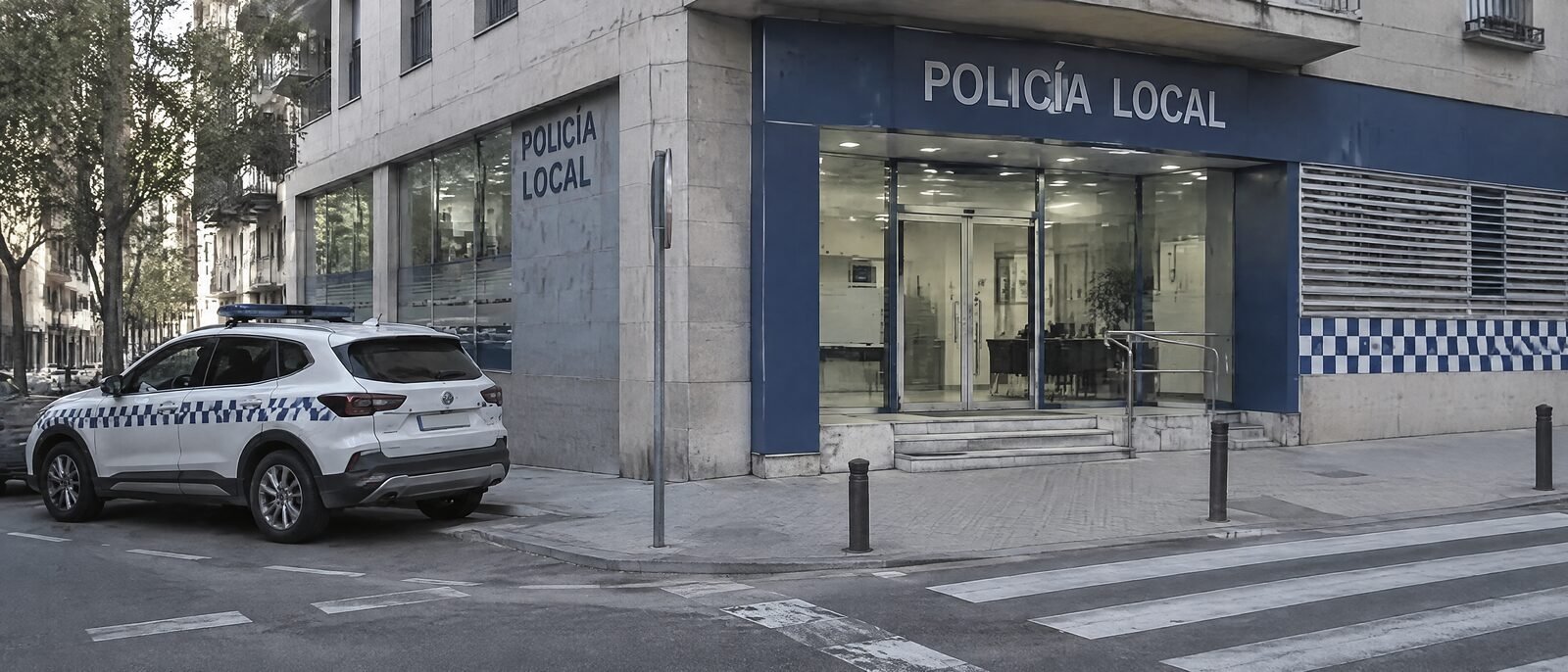 A Mossos d'Esquadra police station entrance on a Barcelona street, blue signage