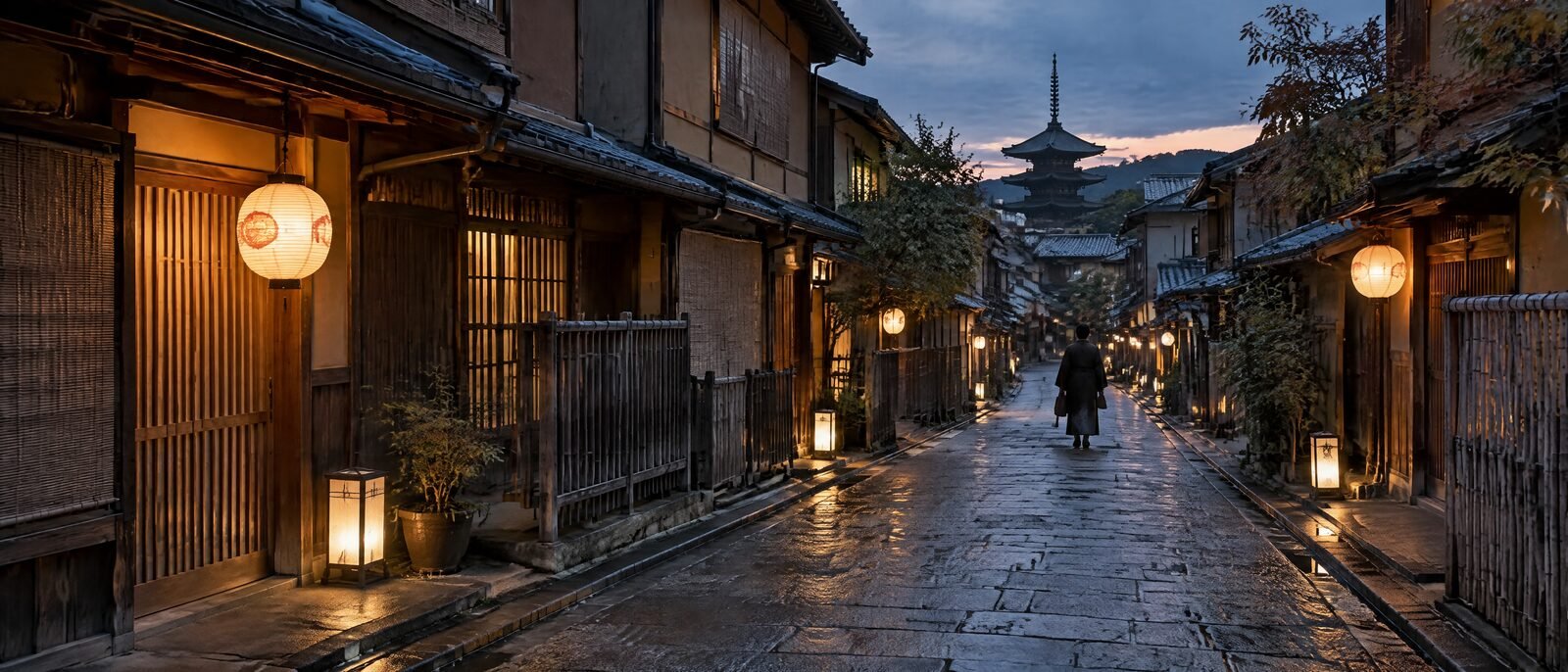 A Kyoto side street of machiya townhouses at dusk with lanterns lit