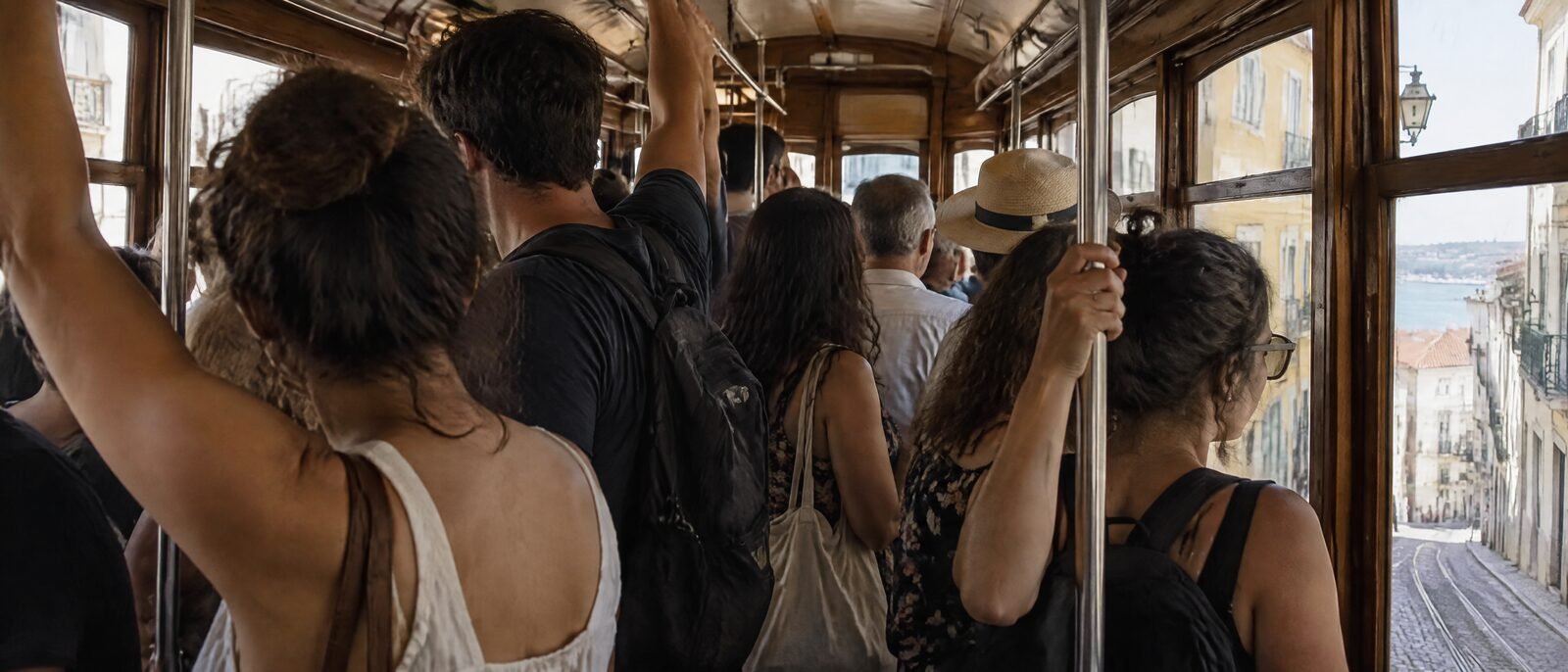 The interior of a crowded tram 28 in Lisbon, passengers standing shoulder to shoulder